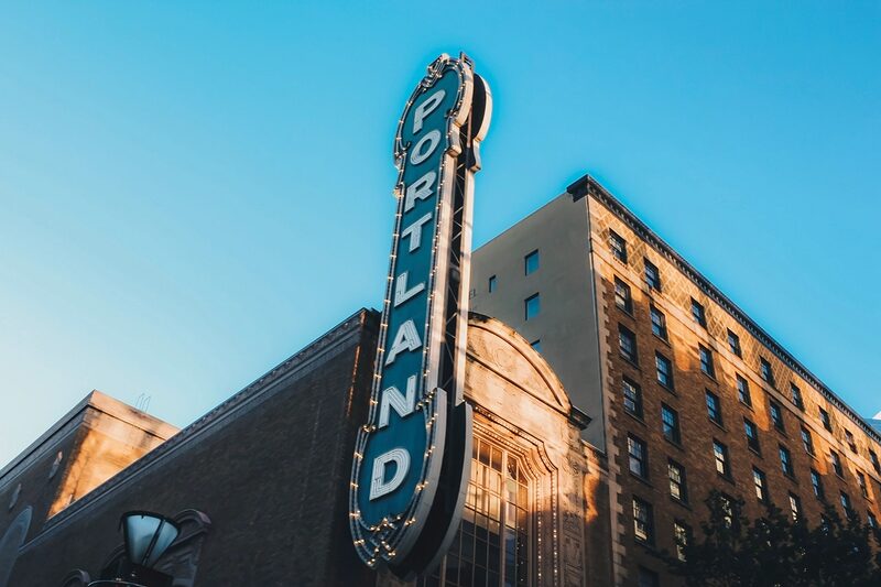 The historic Portland sign lit against the sky in downtown Portland, Oregon