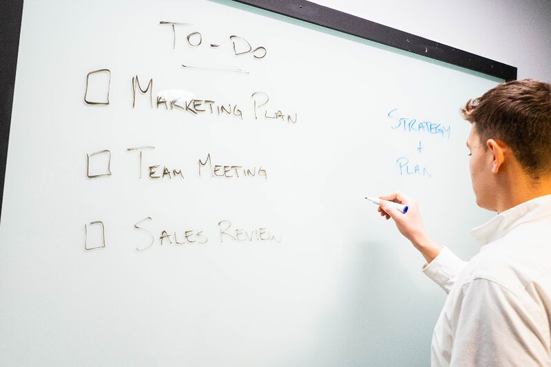A whiteboard to-do list reading marketing plan, team meeting and sales review