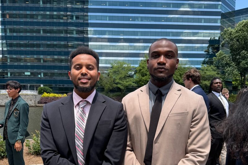 Two True-Alliance Marketing team members standing together outside an office building